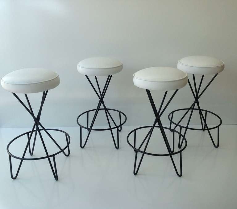 A set of four sculptural bar stools designed by Paul Tuttle.
We just had them newly powder coated and reupholstered is soft white leather.