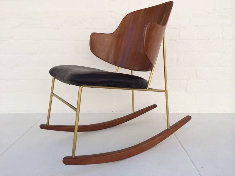This attractive rocker has a newly reupholstered seat in black leather with bent wood back,  brass color painted  frame and wood rockers. 
It is hard to find these penguin rockers as they are very rare.
Circa 1956