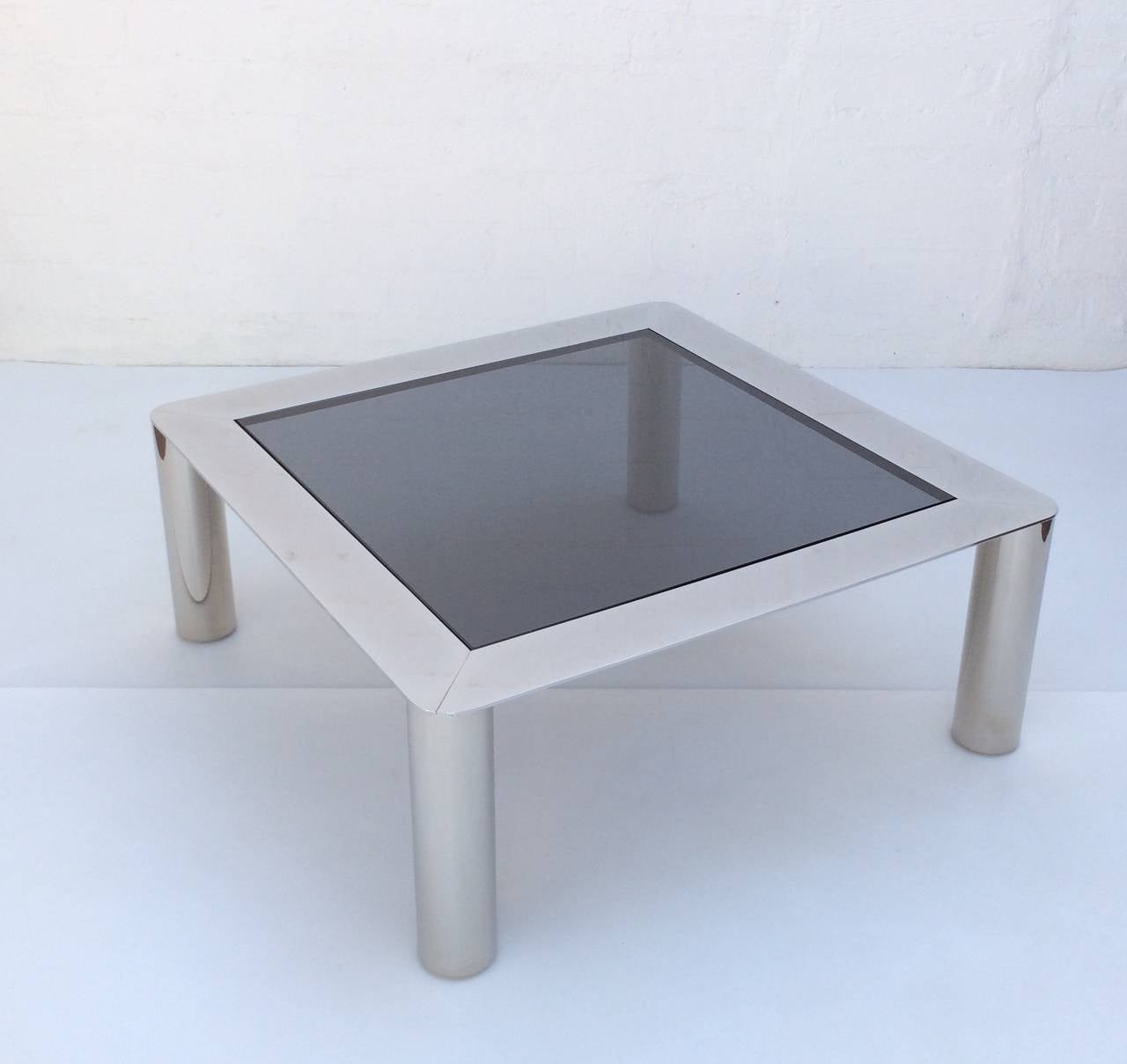Polished stainless steel and smoked glass occasional table. 
Designed by Sergio Mazza & Giuliana Gramigna. 
Made by Cinova in Italy.