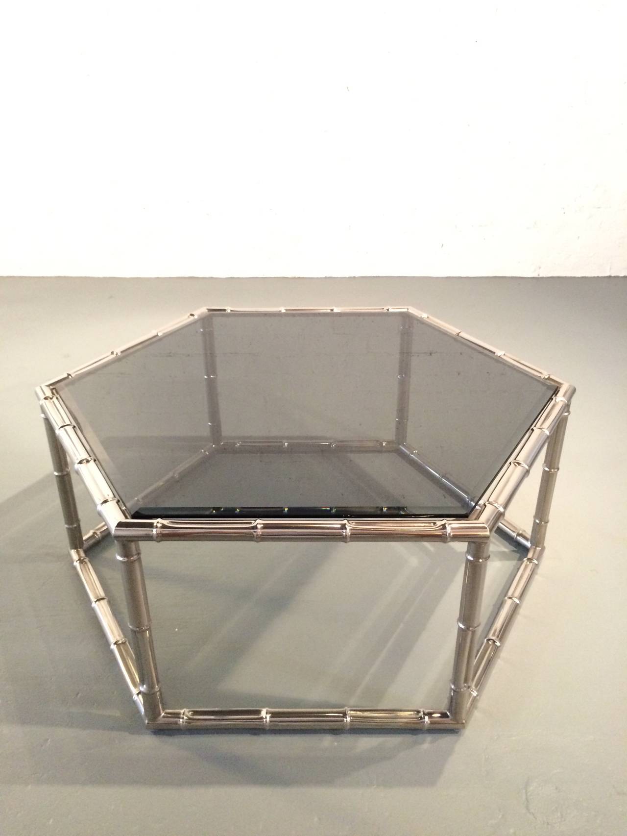 Une table basse ou de cocktail hexagonale en faux bambou fabriquée par Mastercraft. 
Composé d'une base en nickel qui ressemble à du bambou et d'un nouveau plateau en verre fumé biseauté de 1/2