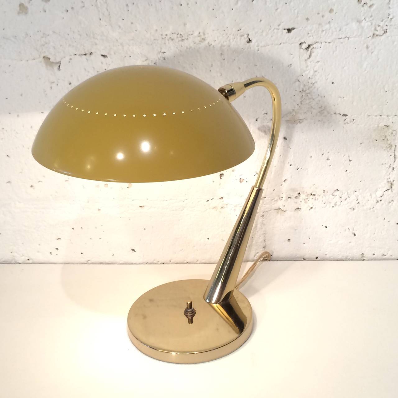 A 1960 desk lamp made by Laurel Studios. 
Brass with a mustered colored painted shade.
Newly rewired.