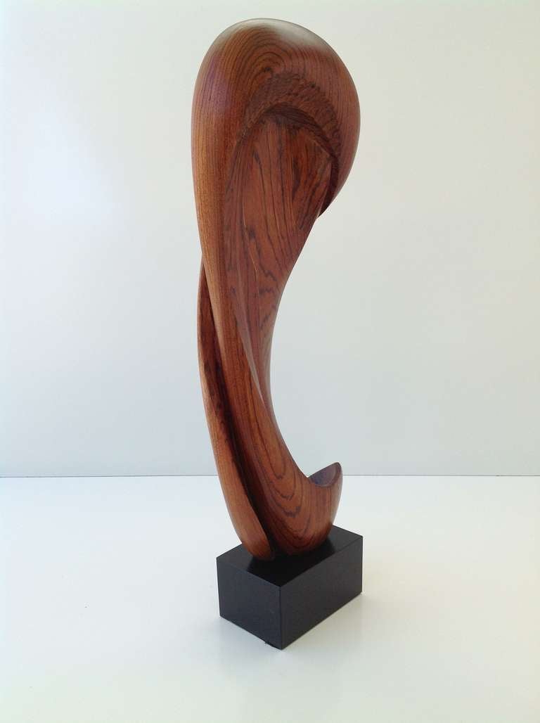 This gorgeous rosewood sculpture is mounted on a black steel base.
It is signed  