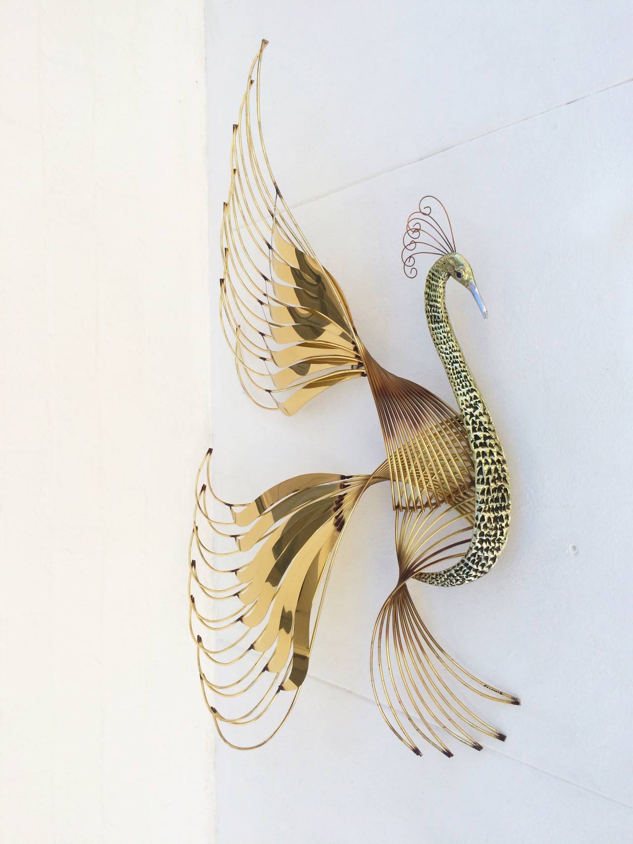 A cast aluminum and brass wall sculpture of a Bird of Paradise. 
Designed and signed by Curtis Jere.