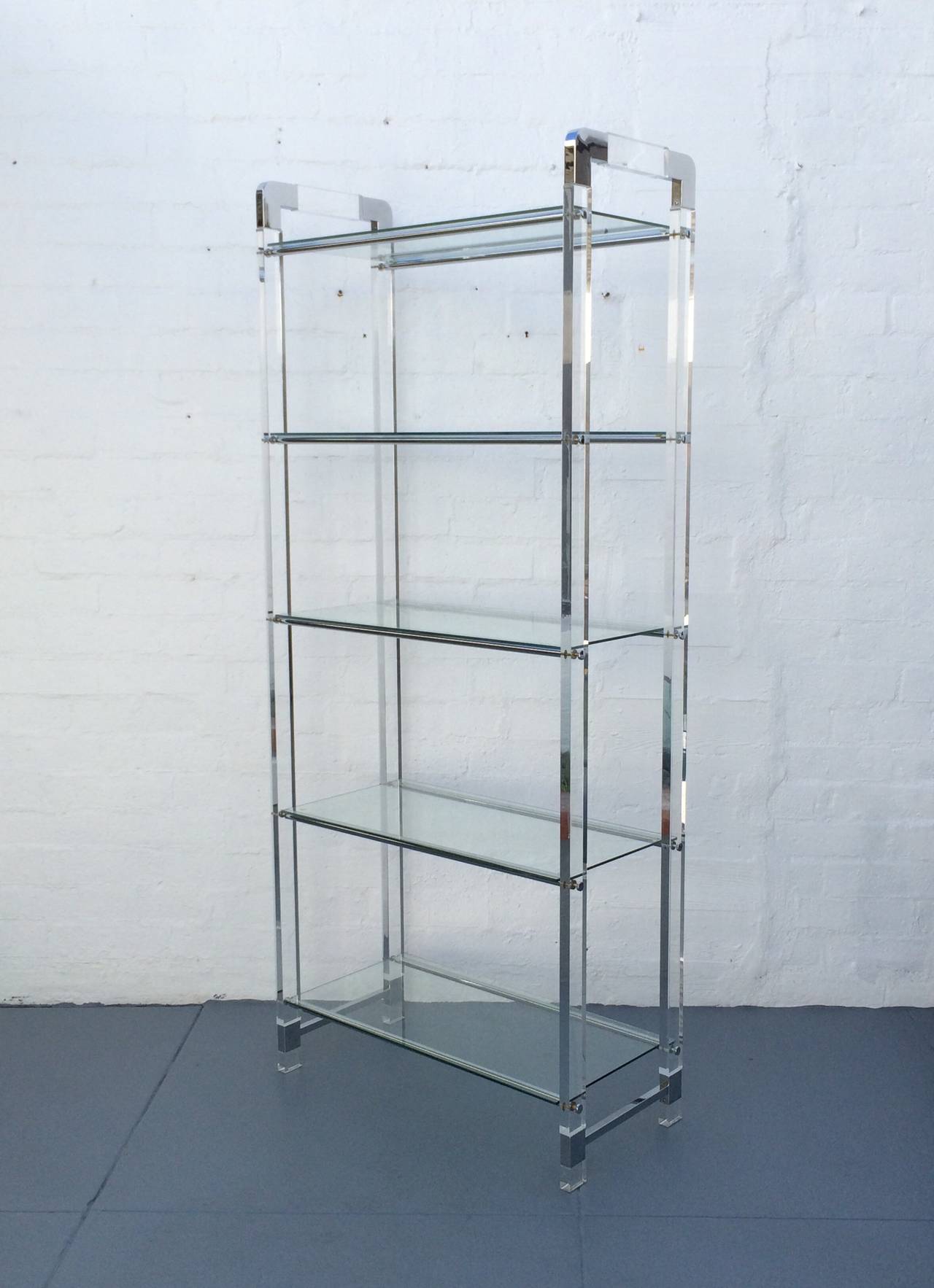 An exceptional pair of acrylic and chrome Etageres designed by Charles Hollis Jones circa 1970s. 
Each has five glass shelves.  
Newly professionally polished.