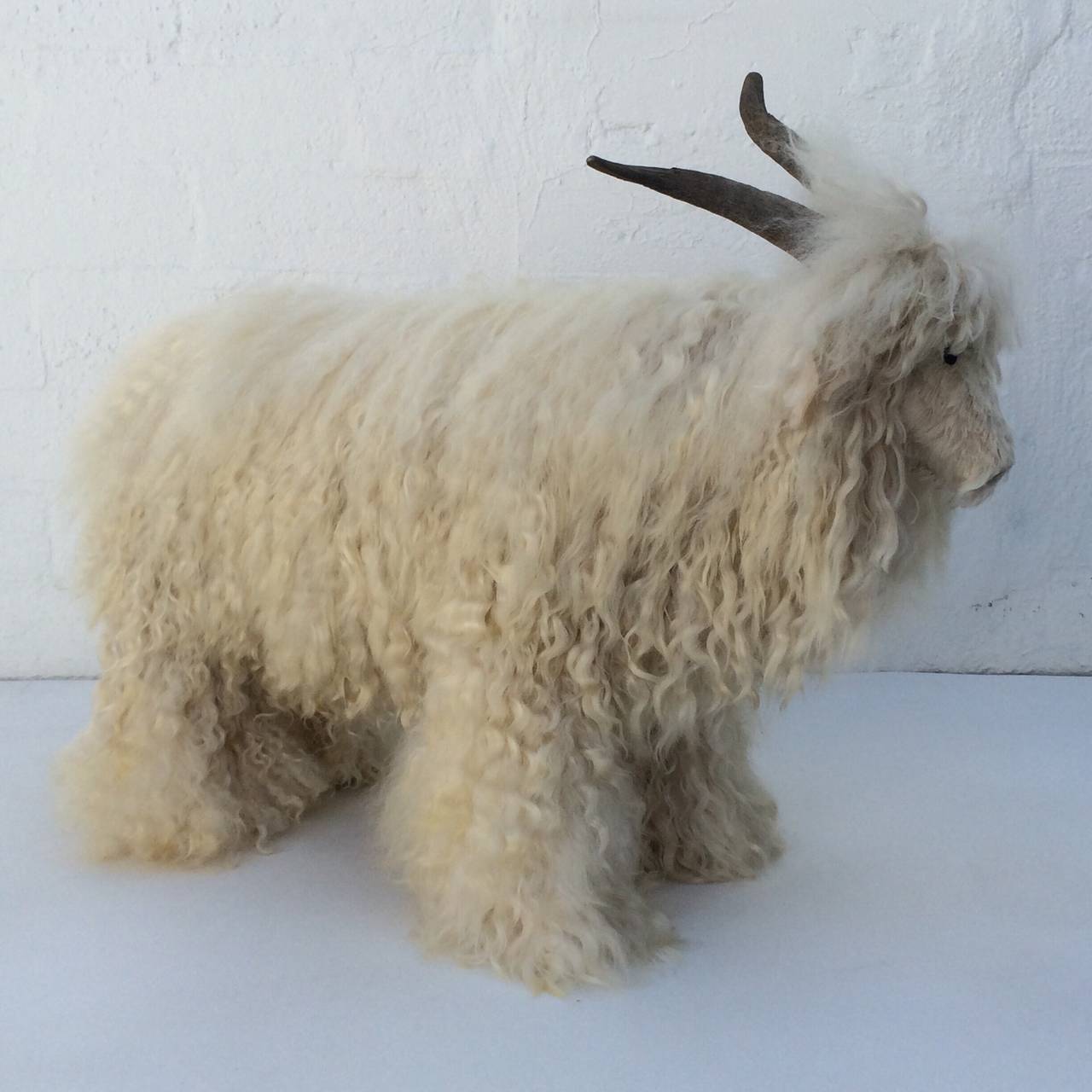 An Icelandic sheep ottoman.
Consist of a sheep shaped wood frame covered in heavy sheepskin and real horns to make up a lifesize Icelandic sheep that can by used as an ottoman or for decoration. 
Circa 1960s
Made in the style of Claude Lalanne.