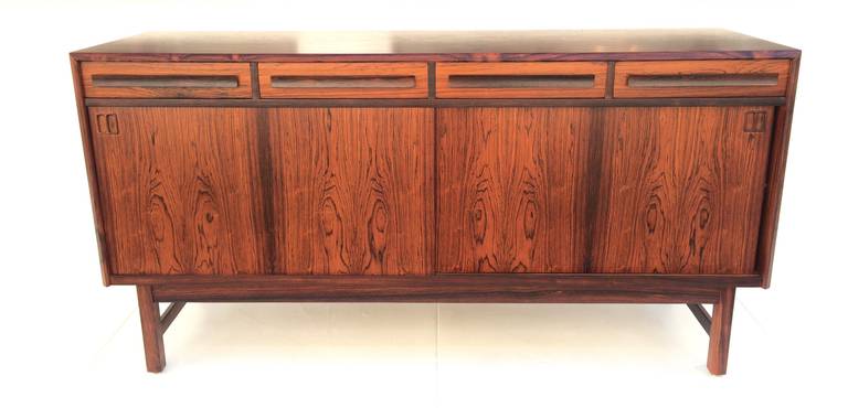 Beautiful rich Rosewood buffet with four drawers across the top, two are felt lined, with one of the felt lined having a second sliding drawer within it. 
The lower part is two sliding doors that conceal two shelves. 
The inside is oak, including