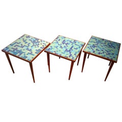 A set of three glass tile top occasional tables