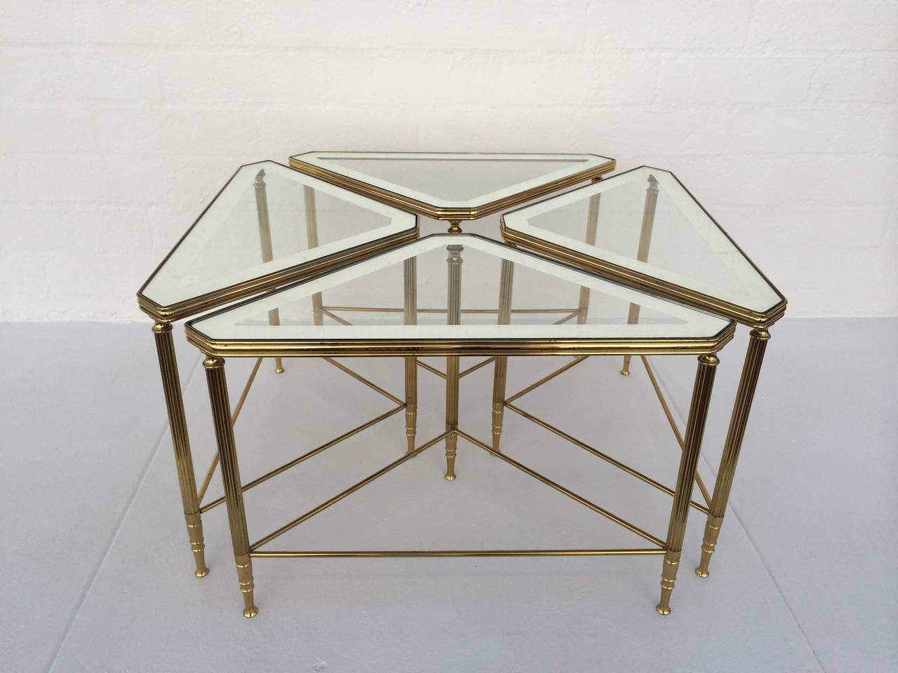 A set of four brass with glass inset tops that have a 2