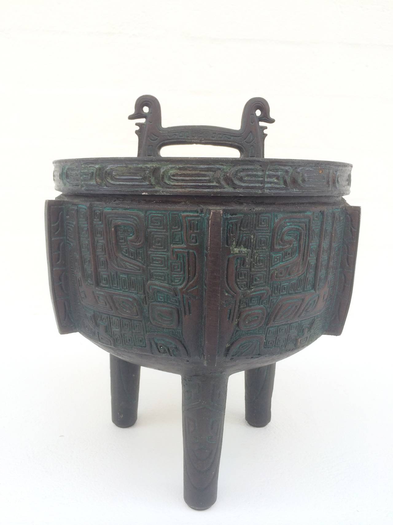 This Mayan inspired ice bucket is attributed to James Mont, circa 1960.
This is the large one, as they also made a much smaller one. 
The outer part is cast metal with stainless steel inside and light blue plastic under the lid and at the rim to