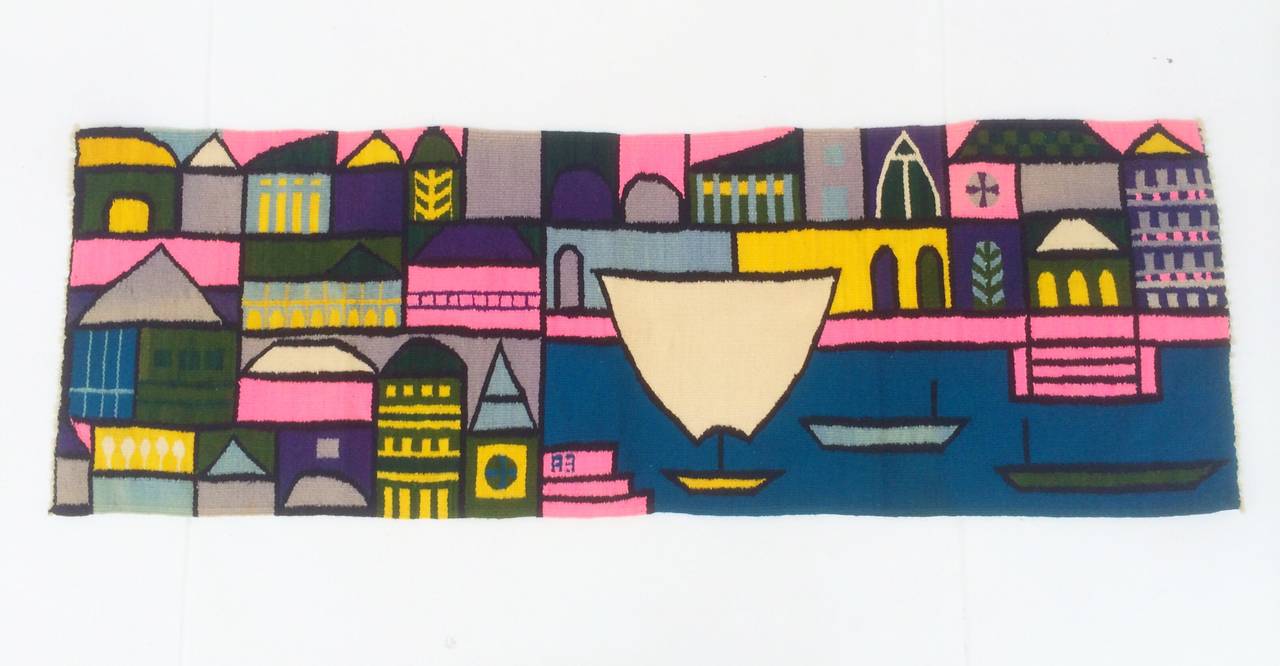 This gorgeous colorful tapestry was made in 1962 by Evelyn Ackerman.
It evokes the waterways in Venice, Italy surrounded by densely packed representations of buildings.
The colors are vibrant!
