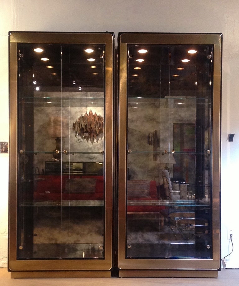 A pair of gorgeous Mastercraft Brass & Glass Vitrines.
Each Vitrine has three adjustable glass shelves, with two lights.
There is a light dimmer control in each unit, or both can be controlled from one unit.
The back panels are antique mirror.