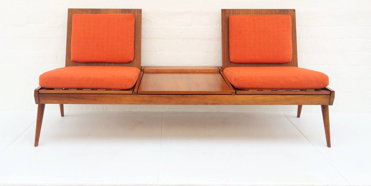 Is it a sofa? Is it table? Is it a bench?
The answer is, it's all three!
This wonderful designed sofa by Brown Saltman, circa 1950 is walnut, folds down to become a coffee or cocktail table, or you can set the loose seat cushions on top when