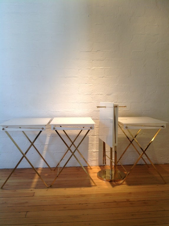 Four white folding lucite & brass serving trays with brass stand. Designed by Charles Hollis Jones.
