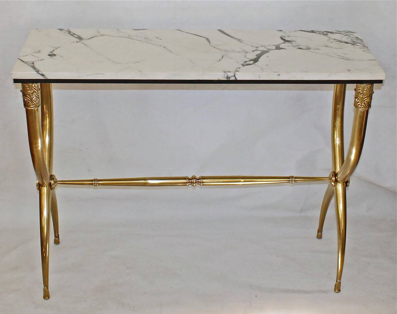 Nicely detailed Italian hall or console table with white marble top and curule form  brass base.
