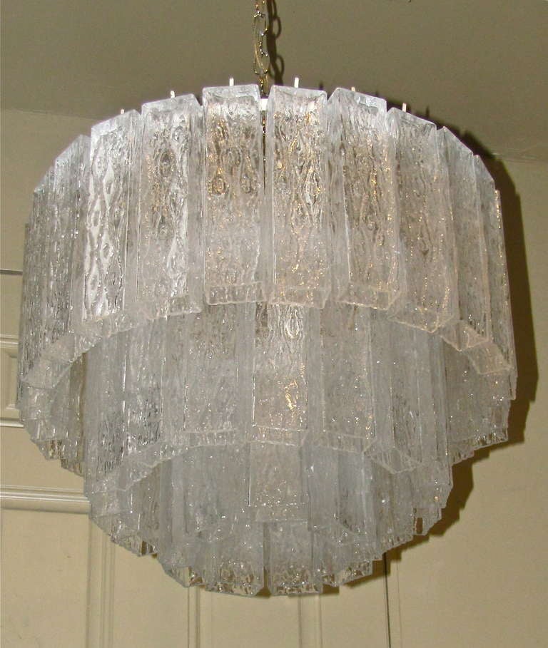 Beautiful Murano glass chandelier with 3 tiers of unique rectangular shaped textured glass on a white steel structure frame. 12 candelabra base sockets, newly wired. 

Chandelier size: 23