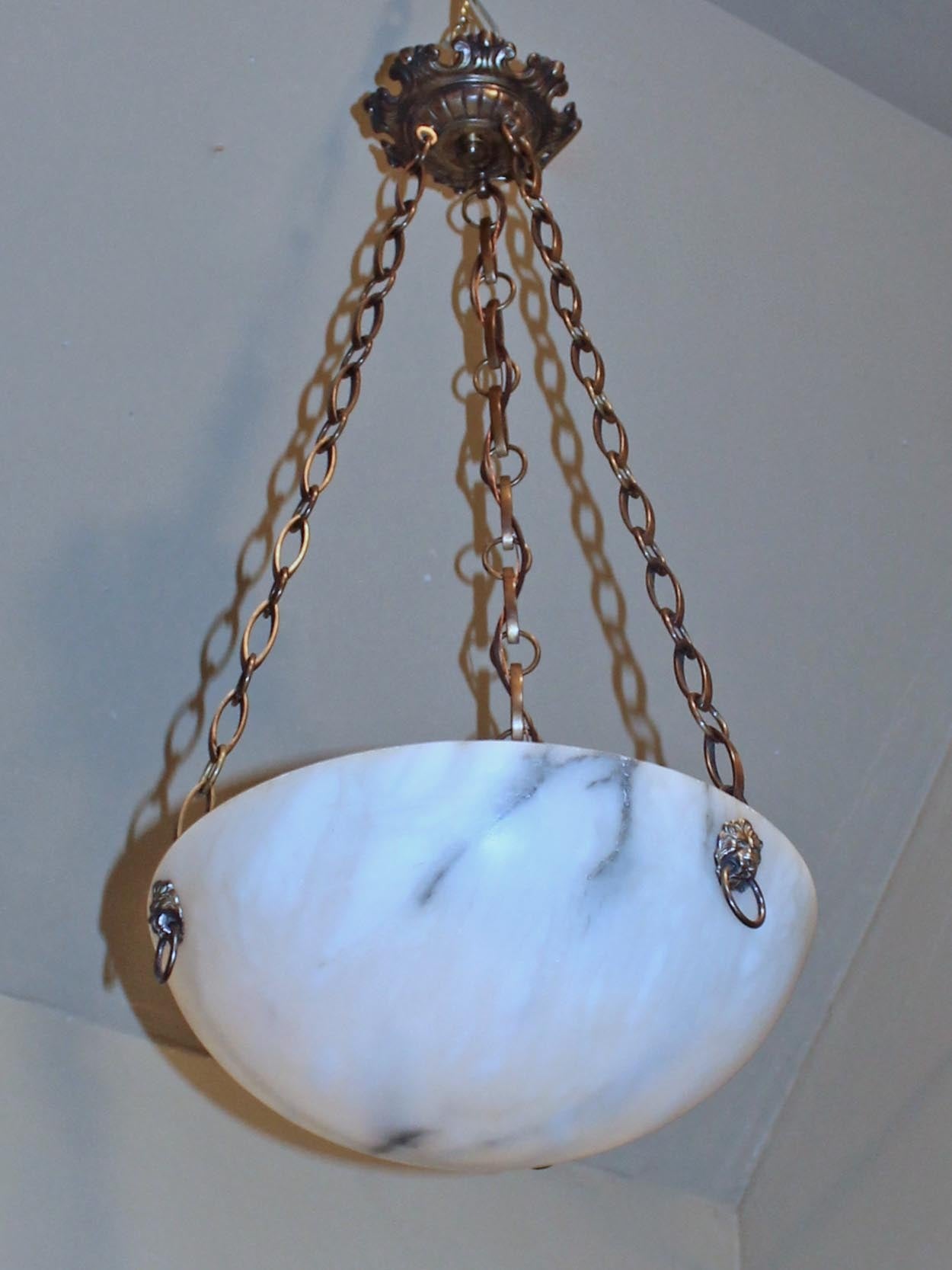 French alabaster chandelier or pendant with brass patinated fittings in the Second Empire style including lion head escutcheons. Newly wired. Uses 3 - 40 watt max candelabra base bulbs.