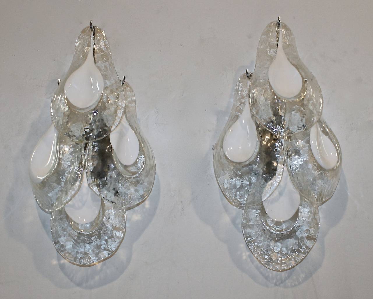 Pair of Italian Mazzega glass clear and white glass tear drop wall sconces with chromed metal backplates, newly wired. Each sconce uses 2 - 40 watt max candelabra base bulbs. Later added white painted backplates for US installation can be painted to