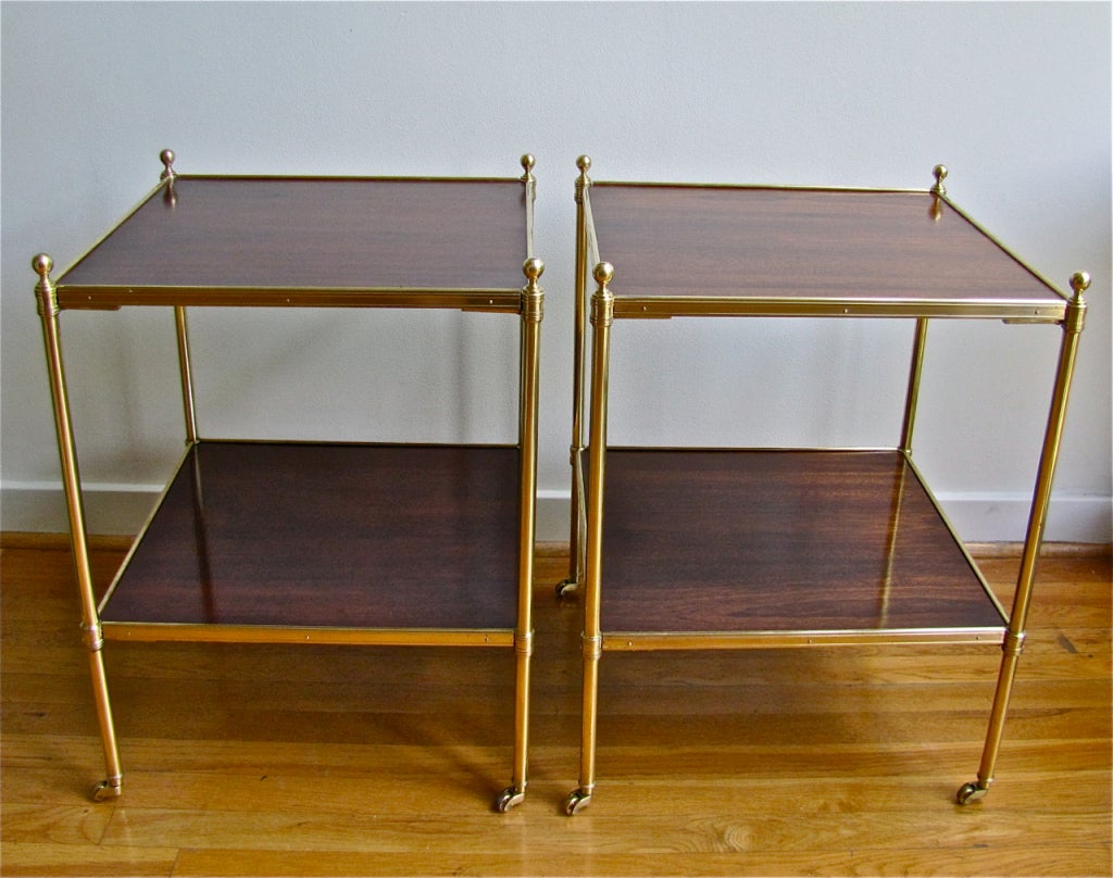 Pair of 2-tier brass and mahogany insets tops with brass castors.