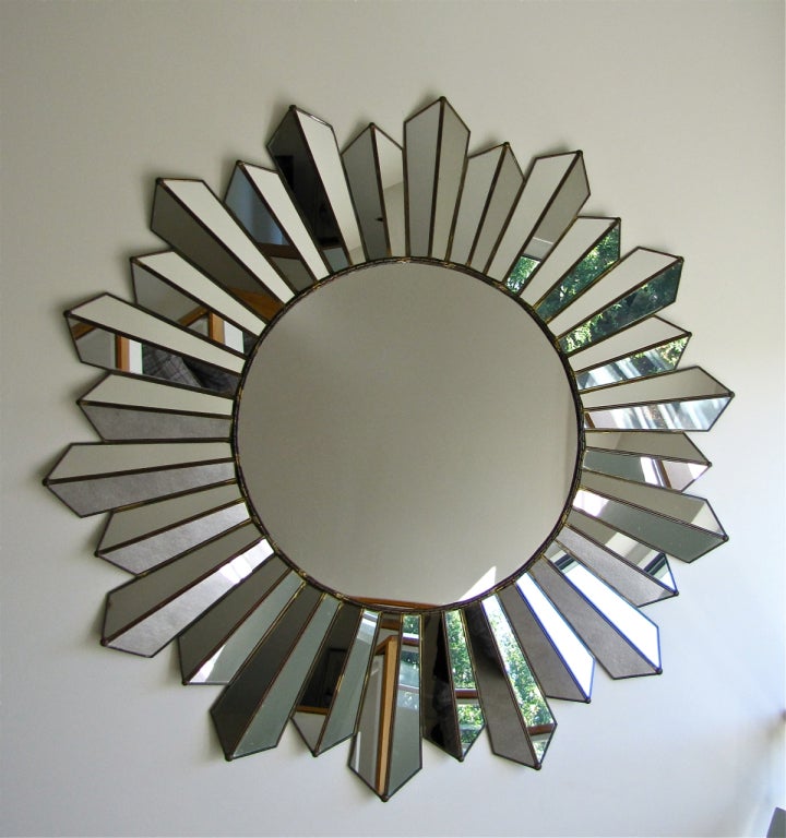 A large soleil wall mirror with angled "ray" panels providing eye catching kaleidoscope effect.