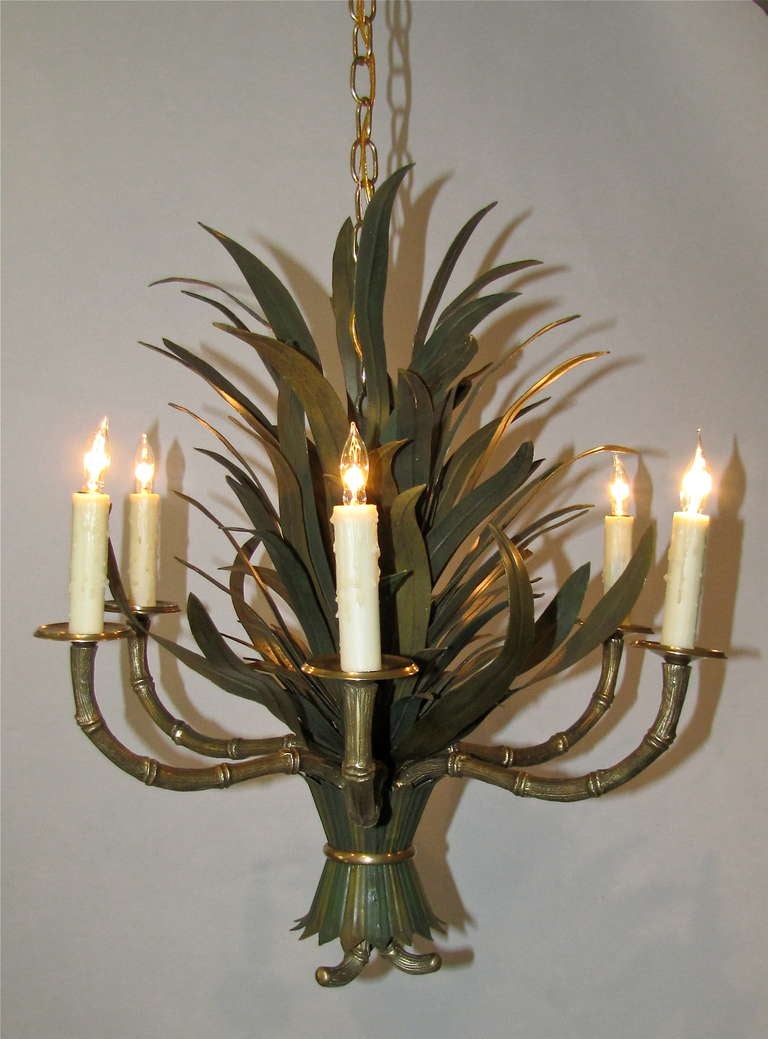 French bronze faux bamboo 6 arm chandelier with painted tole palm leaves, attributed to Maison Bagues. Uses 6 - 40 watt chandelabra base bulbs. Includes waxed candle sleeves, brass chain and ceiling canopy. Rewired.