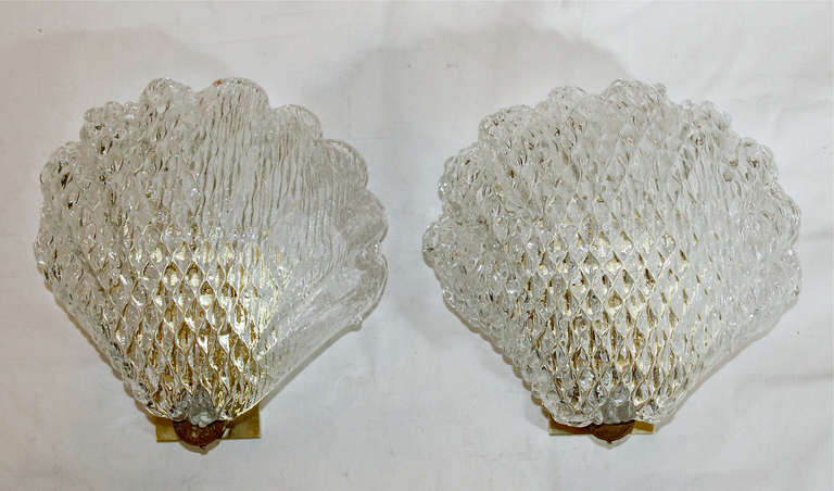 Pair of Murano glass clam shape wall sconces supported on brass backplates. Each sconce uses 1 - 40 watt max candelabra base bulb. Newly wired for US. 

Backplate will fit over a US switch or gem box.

 