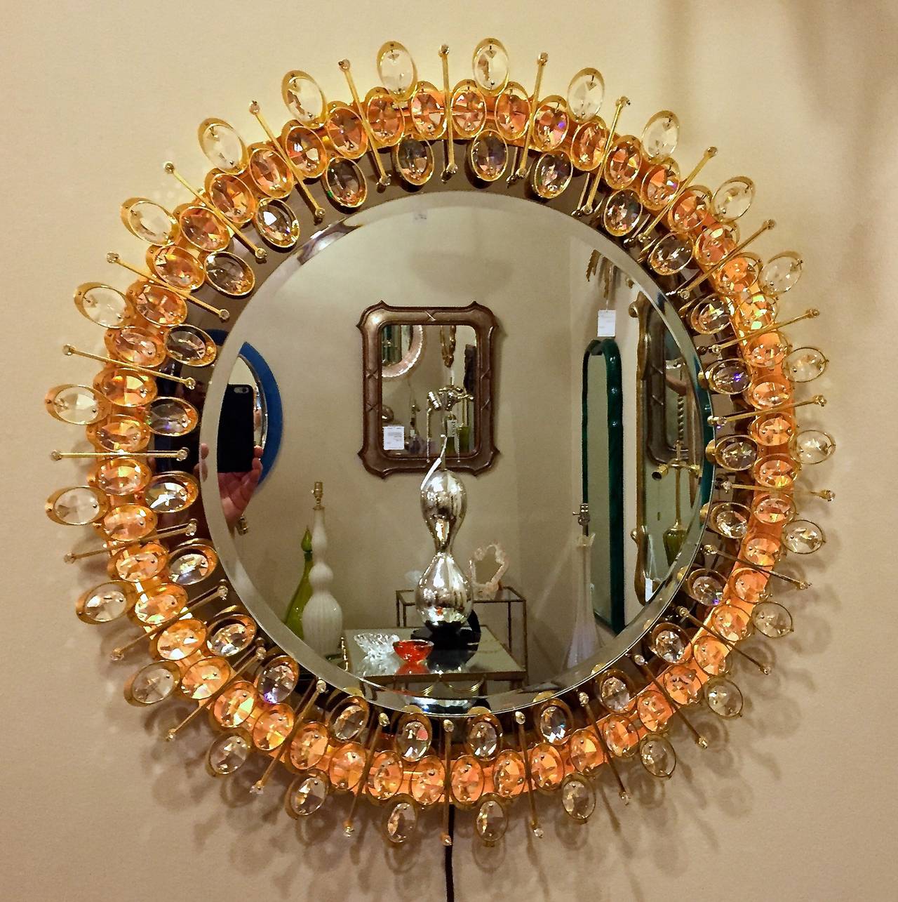 A stunning and rare round gold-plated and crystal illuminated backlit wall mirror by Lobmeyr. Incredible quality. Grey mirror surrounds clear mirror. Polished and matte gold plated finish on brass frame. Rewired.