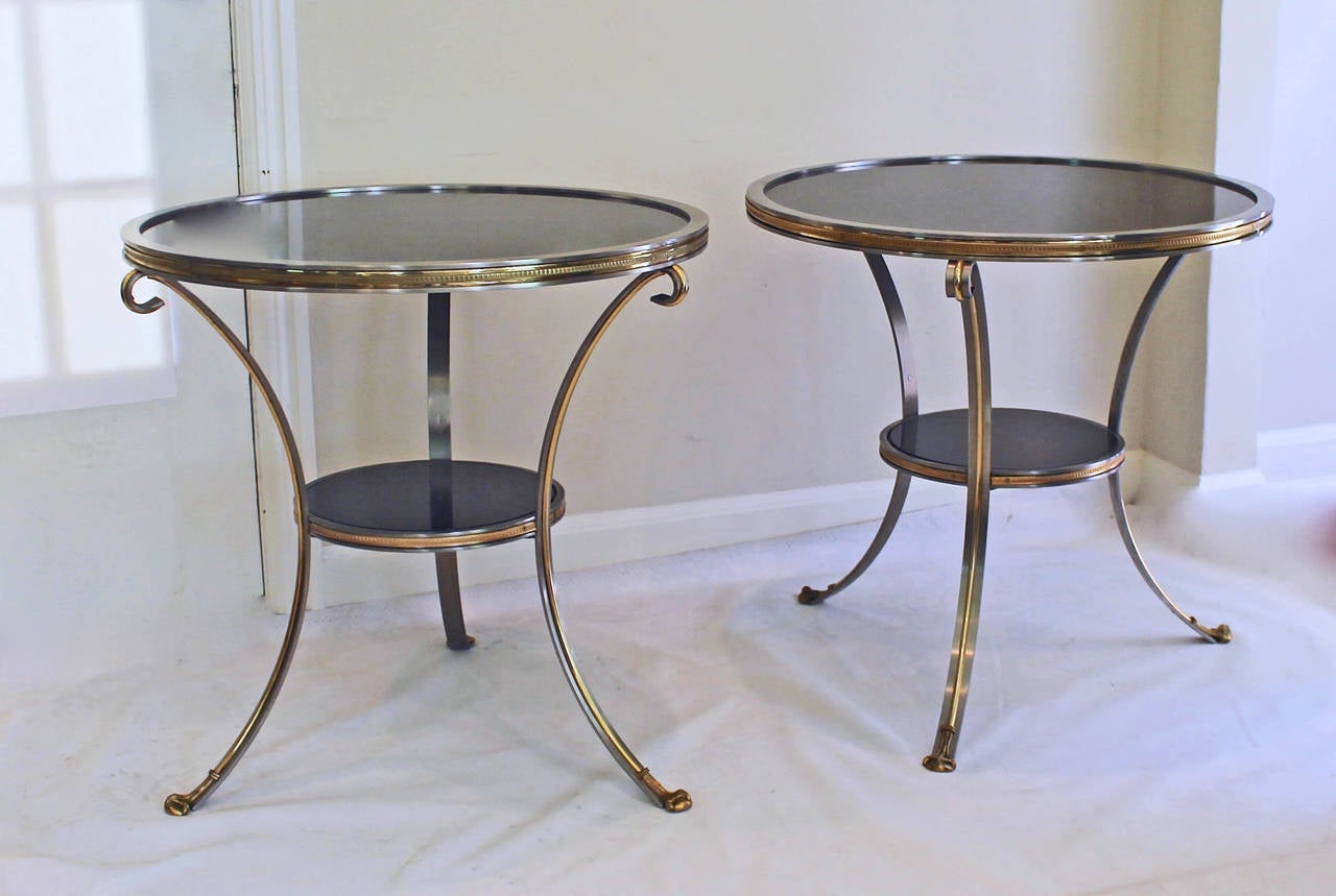 Beautiful pair of large-scale brushed steel and gilt bronze gueridons or side/tables in the style of Maison Jansen. Expertly crafted, beautifully chased and detailed bronze ormolu mounts in a d'ore gilt finish have a beautiful patina. Tables are