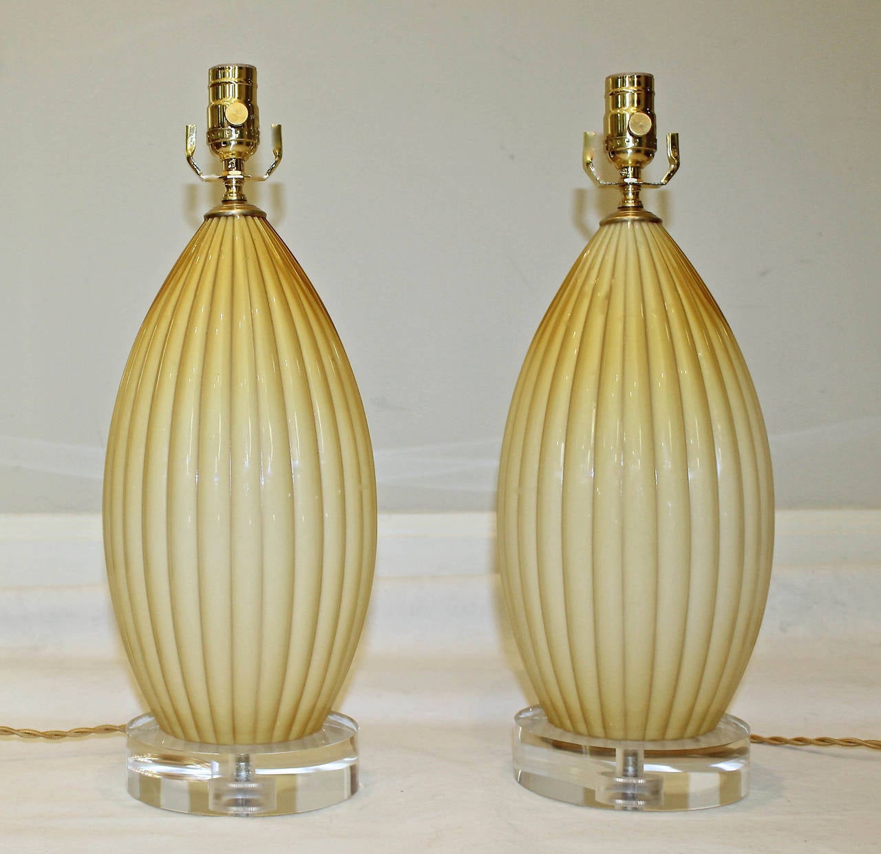 Pair of Murano cased glass lamps in a butterscotch color on new custom acrylic bases. Newly wired for US with French style twisted rayon covered cords, lacquered brass fittings and on/off sockets. 

Measures: 15