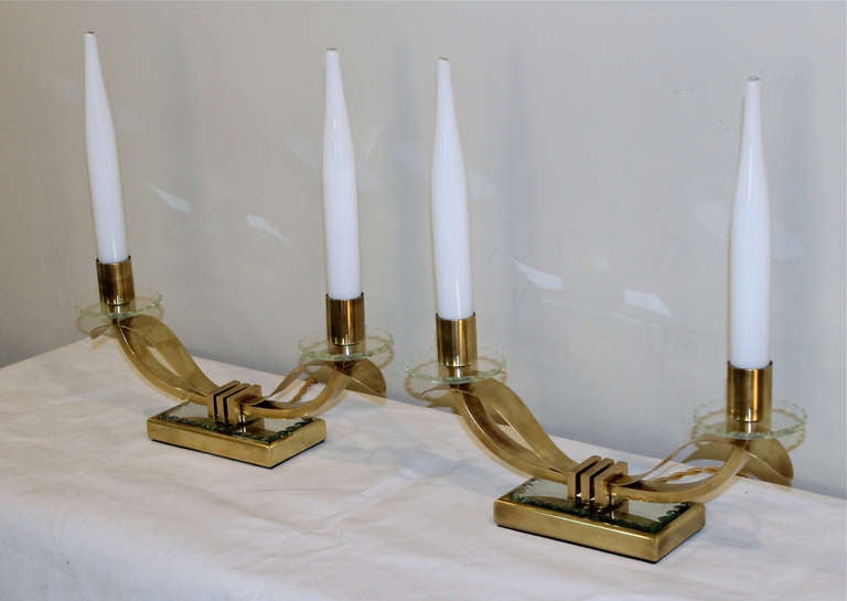 Pair of French brass and mirrored two-light mantel lamps in the manner of Jules Leleu. Each light socket has a tapered opaque shade. Newly wired for the US with French style cords. Each sconce uses 2-40 watt max candelabra base bulbs.

