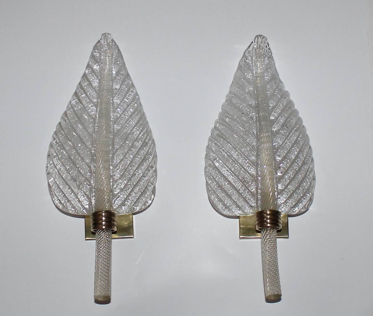 Beautiful pair of Murano glass wall sconces in leaf shape form, manufactured by Barovier & Toso in the early 1950s. Finely twisted glass stem infused with gold flecks and the reverse side of the leaf in the 