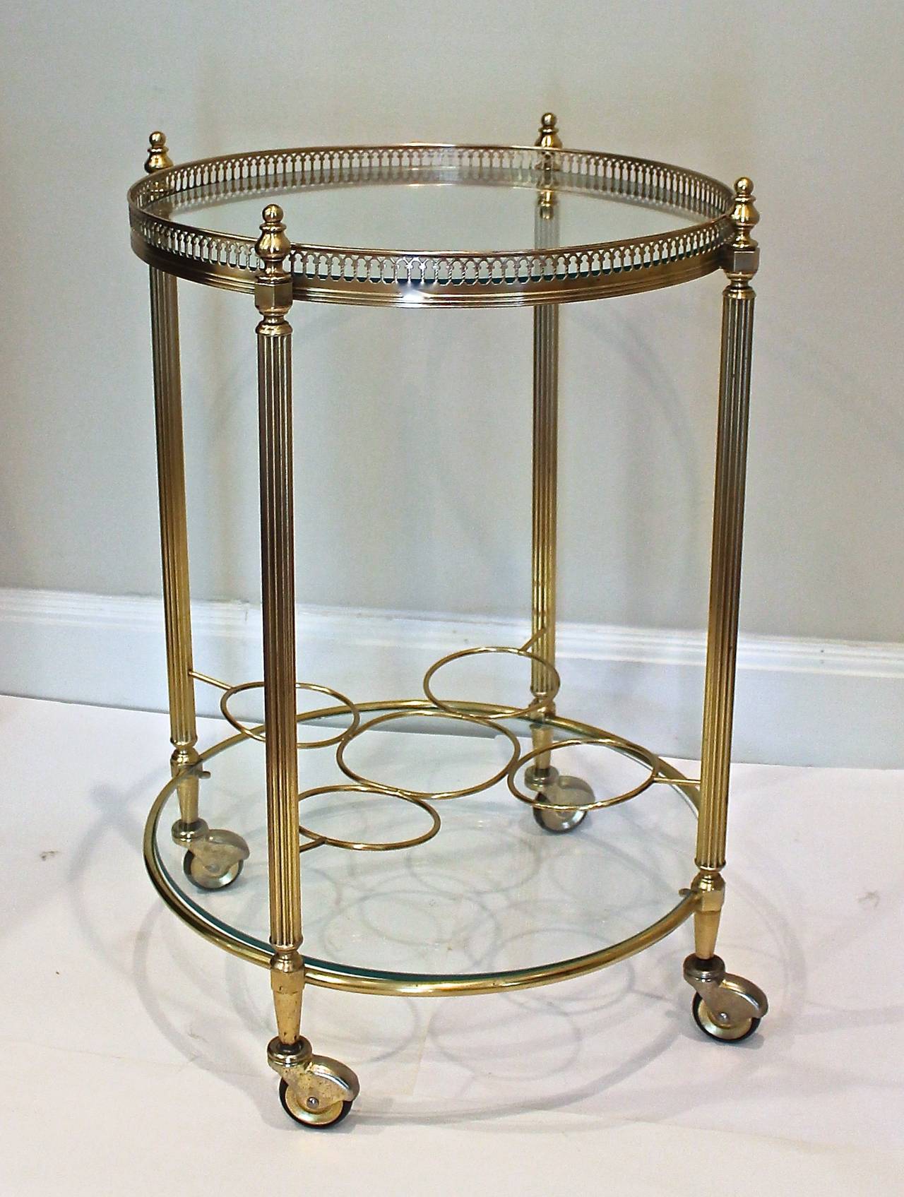French diminutive 2 tier brass bar cart on casters with glass inset shelves and bottle holder.