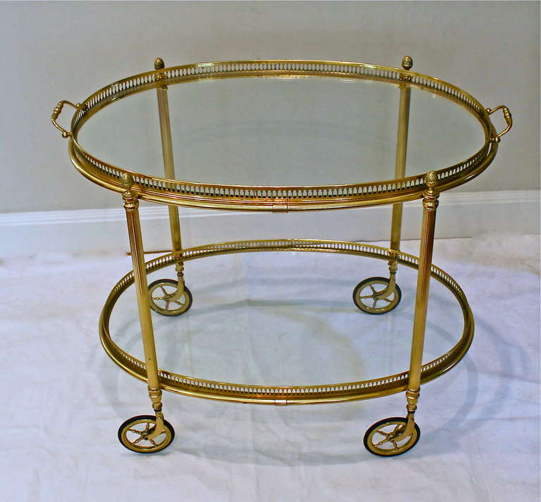 Beautiful vintage French brass bar cart with reeded legs and removable glass inset top tray. Nice detailing including acorn finials and brass wheels.