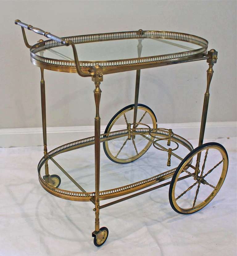 Vintage French brass bar cart with 2 tier glass inset shelves and beverage holder. Beautiful detailing.