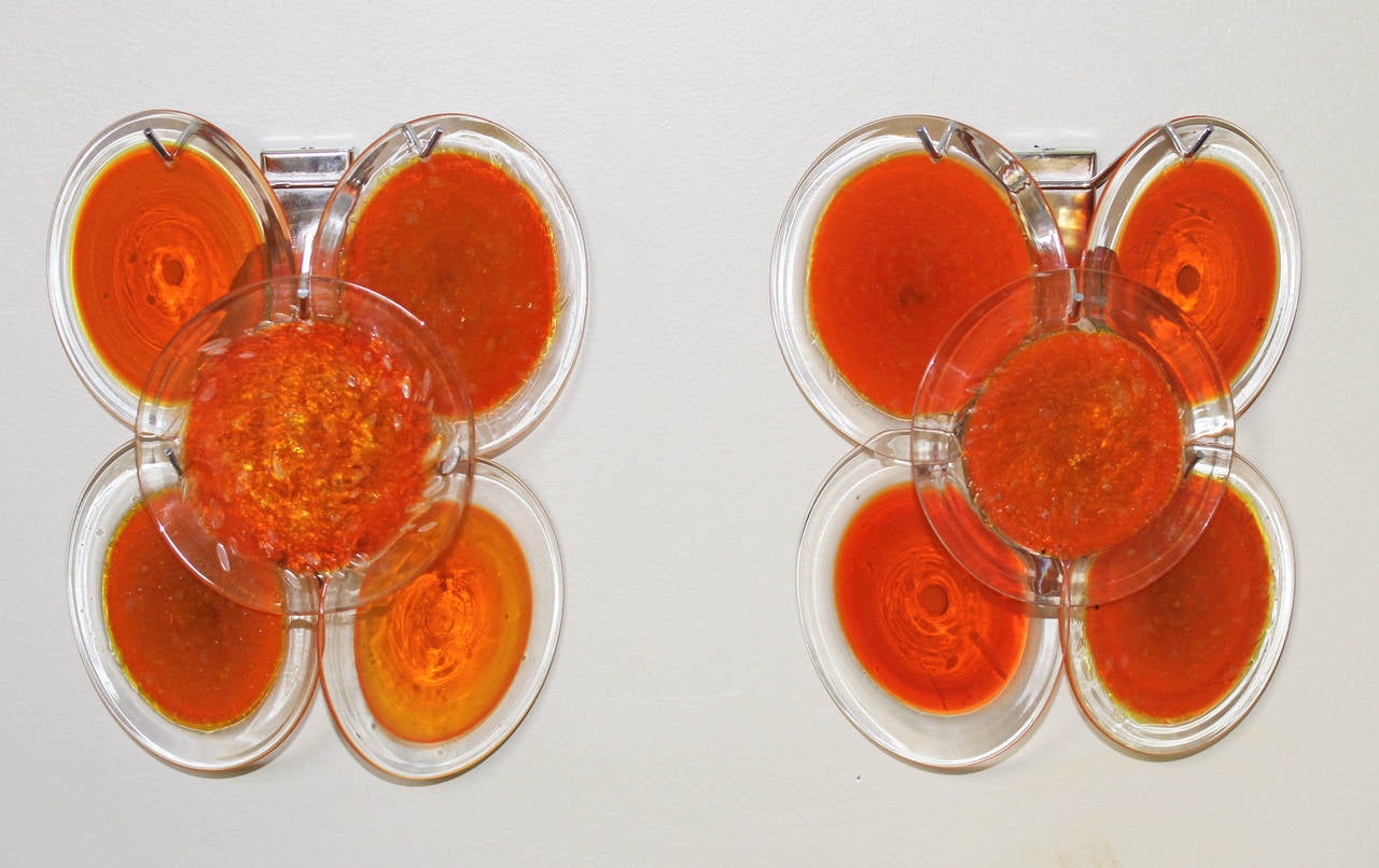 Pair of Vistosi orange glass disc sconces in chrome plated backplates. Newly wired, each with 1 - 40 watt max candelabra size bulb. Deep orange color discs with two alternating styles as seen in close ups.
