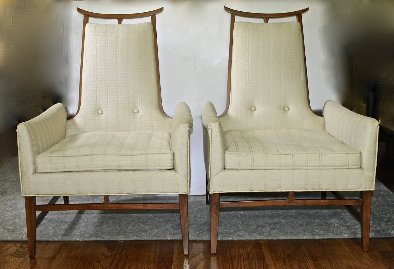 Beautifully crafted Mid-Century Asian inspired upholstered lounge or armchairs in the styles of James Mont or Tommi Parzinger. Unusual pagoda top and exposed legs are walnut. Crafted in New York in the late 1950s and specified by a prominent Dallas