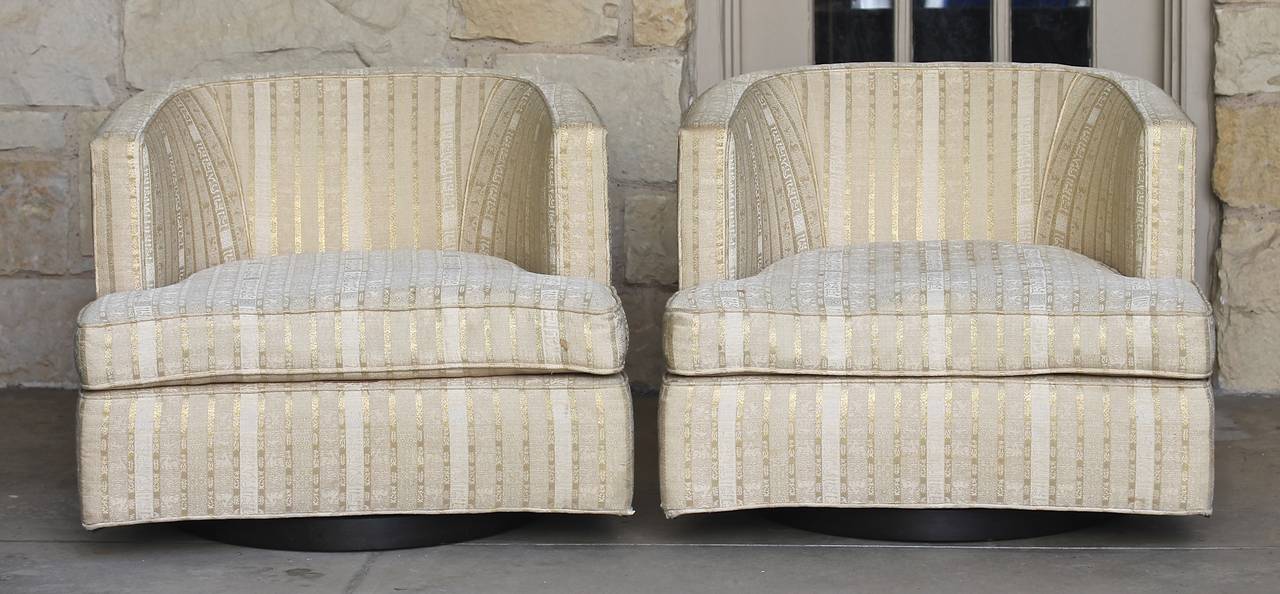 Pair of barrel lounge chairs by Harvey Probber with walnut round swivel bases. This pair of chairs is in the original fabric and upholstery. Retains the original Harvey Probber label to decking.