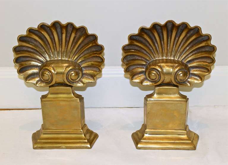 Pair of vintage solid brass shell form andirons. Great patina to brass.