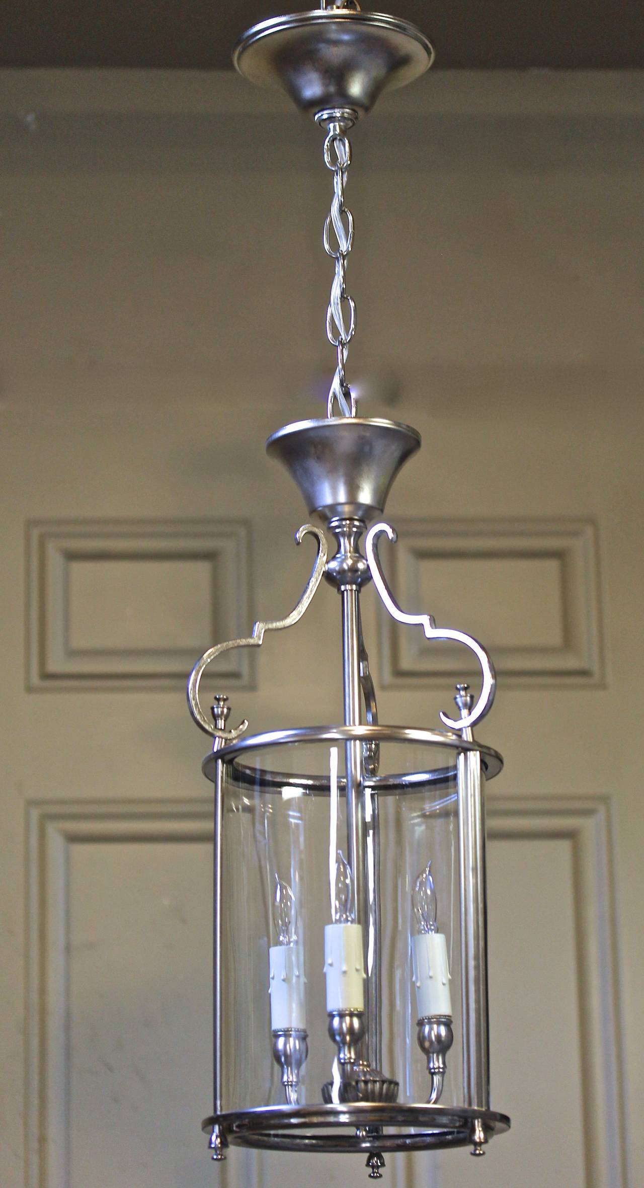 Italian brass Neoclassic solid brass hall lantern in silver plated finish with a single cylindrical glass shade and 3 lights. Uses 3 - 40 watt max candelabra base bulbs, newly wired. Fixture 8