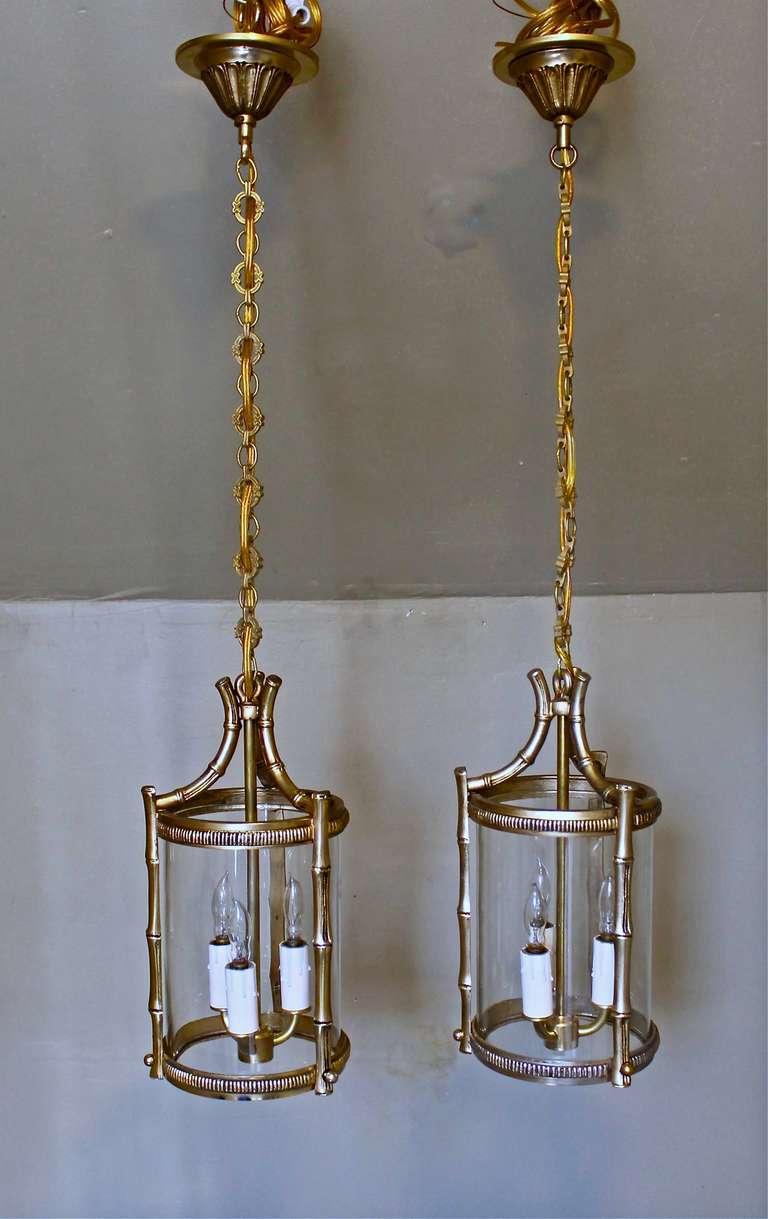 Pair of French faux bamboo brass finish three light hanging pendant ceiling light. Newly wired, each takes three 40-watt max candelabra bulb. Overall size including chain and ceiling cap 30.5".