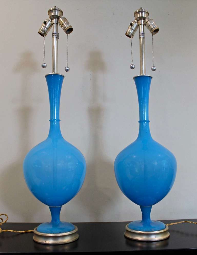 Pair of vibrant blue Swedish glass table lamps by Marbro Lamp Company. The color and shape make these true statement pieces. Mounted on the original custom silver gilt wood bases and retain the original silver plated fittings and Marbro foil labels.