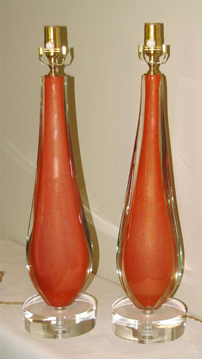 Very hard to find pair of Italian hand blown rich orange with gold inclusions glass table lamps by Flavio Poli for Seguso. Lamps are extremely heavy and exceptionally well crafted. Mounted on new custom acrylic bases with French style twisted rayon