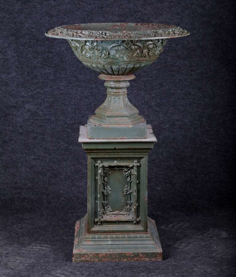 American 19th century urn with base in cast iron.  This piece has beautiful detail work on the urn, its rim and base; as well as faux bois and leaf decoration on each side of the pedestal.