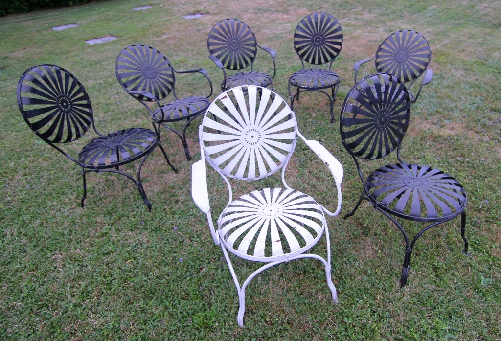 Vintage sunburst garden strap chairs in the style of Francois Carre, American 1940's.  Three armchairs remaining with one matching pair.