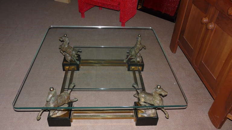 A very rare table by Claudio Trevi made of four patinated bronze horses , golden brass and two levels glass top.