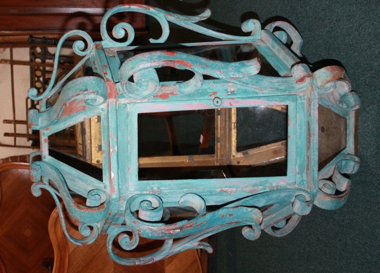 This is a pair of antique iron lamps. They were painted a turquoise blue a long time ago. There is evidence of chipped paint that gives a good looking patina. They might have been a red color previously. They are quite heavy weighing about 100