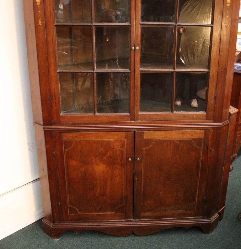  This is a circa 1790 American Federal Walnut Corner Cabinet. It has a warm patina with good satin  wood inlays of a primitive American eagle and floral displays.  This cabinet has lots of room for display pieces and storage. It is very well built