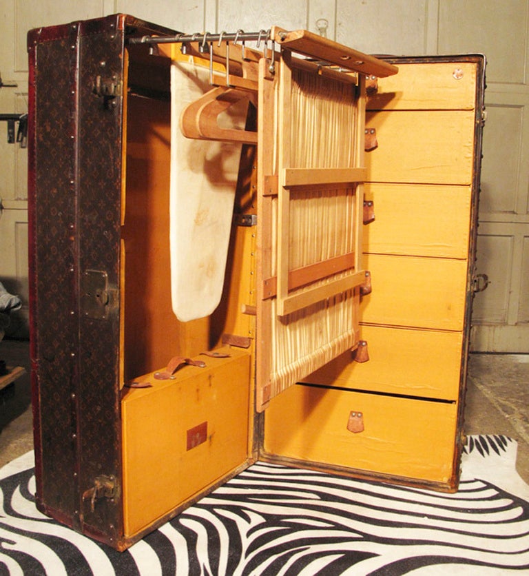RARE Louis Vuitton Wardrobe with Ironing board c.1905 in excellent antique condition.  Louis Vuitton monogram canvas exterior trimmed with lozine, brass, and wood.  Interior fully lined in yellow canvas and features 6 drawers on one side and a