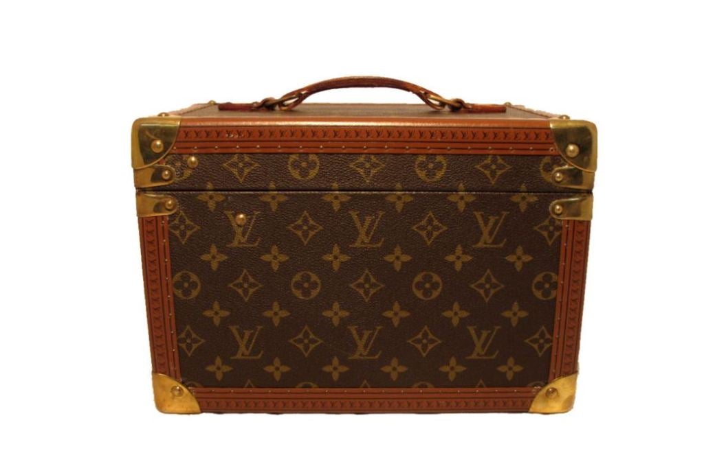 Louis Vuitton train case in excellent condition. Exterior features signature LV monogram canvas trimmed with leather and brass hardware.  Interior holds one small storage box with mirror.  This piece comes complete with the original key and a velvet