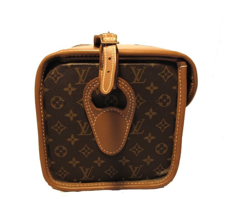 Louis Vuitton shoulder strap cosmetic case in very good vintage condition.  Exterior features signature Louis Vuitton monogram canvas trimmed with tan leather.  Brass latch single flap closure opens to plastic lined brown canvas interior with mirror
