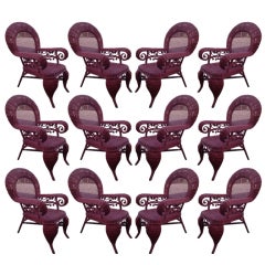 Set of 12 ruby red wicker armchairs of generous proportions